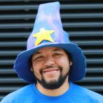 Kevin Kaland wizonesolutions smiling wearing a wizard hat with a yellow star on it and blue T shirt